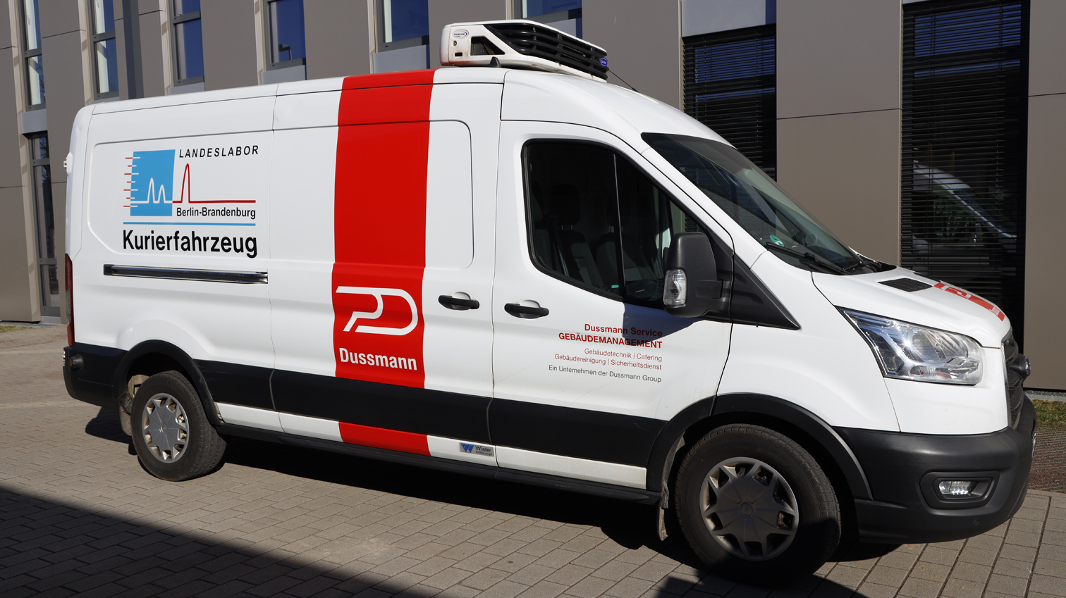 Transporter mit Logo vor dem Gebäude des LLBB